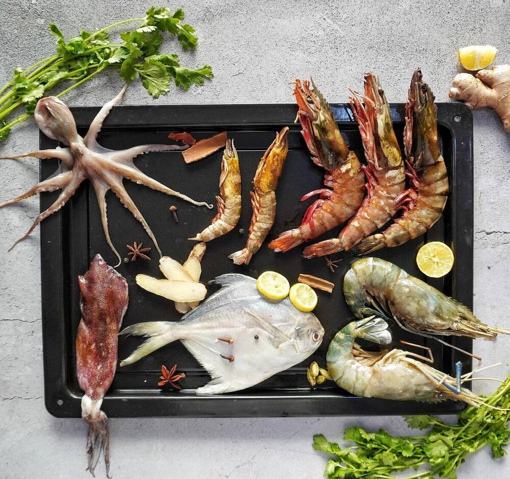 Fresh octopus, prawns, squid and pomfret from Ocean's Surprise laid out for preparation